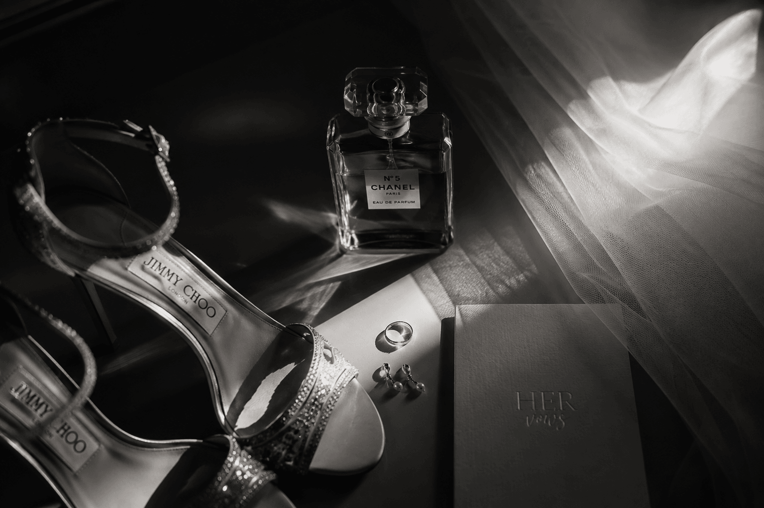 Getting-Ready-Details der Braut: Schuhe, Parfum, Ringe und Gelübde-Buch im Licht des Schleiers